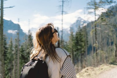 Polonya 'nın Tatra dağlarındaki vadide tek başına seyahat eden sırt çantası takan bir kız yolcunun arkası.