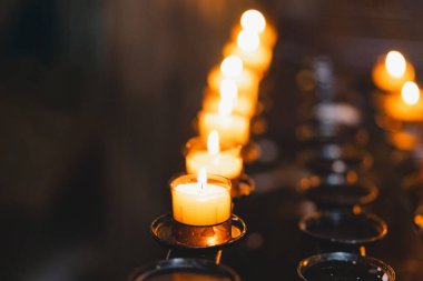 Birçok mum bir katedralde yanıyor. Kilisede dini ayin. İnanç, maneviyat ve din kavramı.