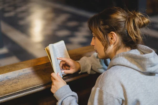 Christian woman reading bible in an ancient Catholic temple. Reading the Holy Bible in temple. Concept for faith, spirituality and religion. Peace, hope, dreams concept