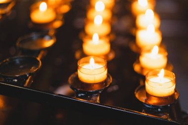 Birçok mum bir katedralde yanıyor. Kilisede dini ayin. İnanç, maneviyat ve din kavramı.