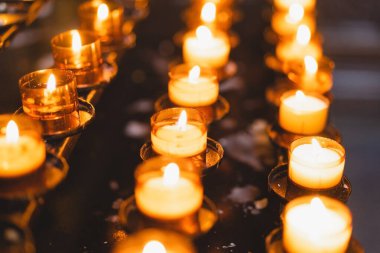 Birçok mum bir katedralde yanıyor. Kilisede dini ayin. İnanç, maneviyat ve din kavramı.