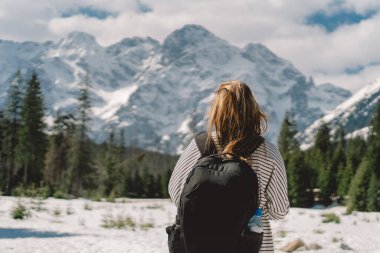 Polonya 'nın Tatra dağlarındaki vadide tek başına seyahat eden sırt çantası takan bir kız yolcunun arkası.
