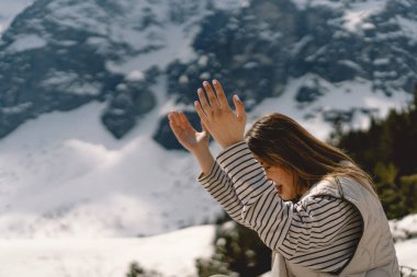 Dağın yanında dua eden bir kadın gözlerini kapadı. İnanç, maneviyat ve din için dua kavramında eller kavuşturuldu. Barış, umut, rüyalar konsepti
