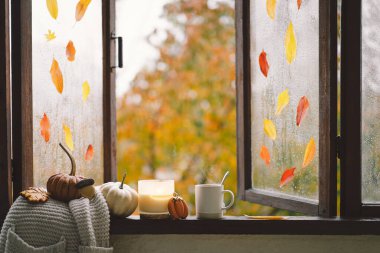 Güzel evim. Evdeki ahşap penceredeki hayat ayrıntıları. Süveter, mum, sıcak çay ve sonbahar dekoru. Sonbahar evi dekorasyonu. Samimi düşüş havası. Şükran Günü. Cadılar Bayramı. Sıcak sonbahar ya da kış konsepti.
