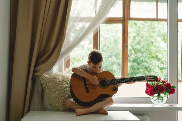 Cute Boy Learns Play Classical Guitar Windowsill Window Cozy Home — Stock Photo, Image