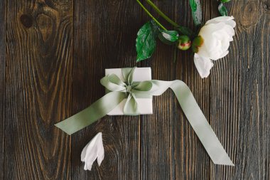 Ahşap arka planda hediye kutuları olan bir buket güzel beyaz şakayık. Şık bir çiçek selamı. Anneler Günü