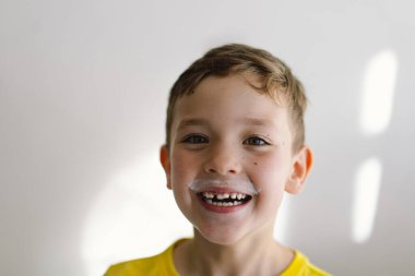 Tatlı çocuk kefir ya da süt içer. Süt bıyıklı bir çocuğun komik portresi. Yaşam biçimi