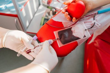 Hastanede kan bağışı yapan genç bir kadın. Bir kadın kırmızı bir kalple kan bağışlıyor. Kan bağışı..