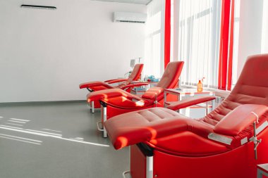 Bağış merkezinde oturmak için kırmızı koltuklar. Kan nakli istasyonu bağışçılardan kan almak için.