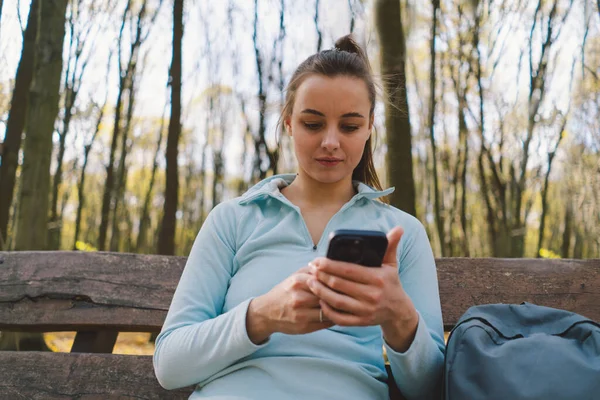 Güzel bir kız telefonu spor ya da yoga için kullanır. Vücut pozitifliği, kadınlar için spor, uyum, sağlıklı yaşam tarzı, kendini sevme ve refah..