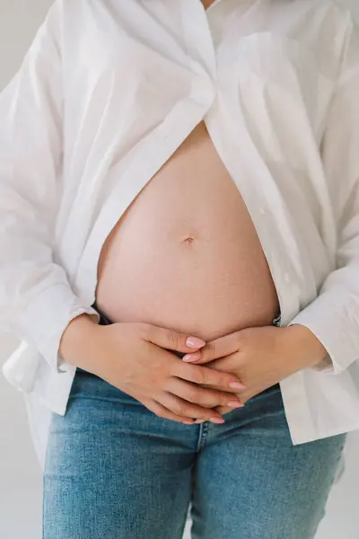Belly of pregnant woman. Close-up belly of a pregnant woman. woman waiting for a newborn baby. Pregnant woman touches her belly indoors