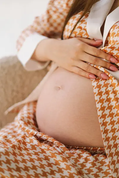 Belly of pregnant woman. Close-up belly of a pregnant woman. woman waiting for a newborn baby. Pregnant woman touches her belly indoors