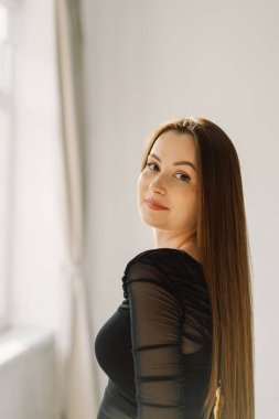 Beyaz arka planda kameraya gülümseyen güzel, neşeli bir kızın portresi. Esmer kız.