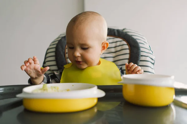 Stock image Little child with solid nutrition. Baby girl eating finger food and mix vegetable plate. Baby led weaning BLW self feeding.