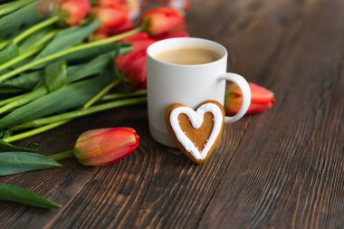 Taze turuncu laleler ve bahar kompozisyonlu kapuçino kupası. Sevgililer Günü, Kadınlar Günü ve Anneler Günü için fotokopi alanı olan tebrik kartı..