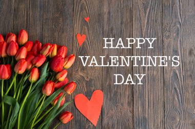 Sevgililer Günün kutlu olsun. Ahşap zemininde tatil kartı olan bir buket taze turuncu lale. Fotokopi alanı Sevgililer Günü olan tebrik kartı