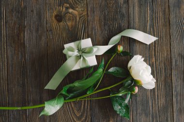 Ahşap arka planda hediye kutuları olan bir buket güzel beyaz şakayık. Şık bir çiçek selamı. Anneler Günü