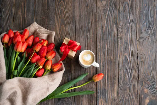Taze turuncu laleler ve bahar kompozisyonlu kapuçino kupası. Sevgililer Günü, Kadınlar Günü ve Anneler Günü için fotokopi alanı olan tebrik kartı..