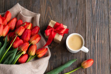Taze turuncu laleler ve bahar kompozisyonlu kapuçino kupası. Sevgililer Günü, Kadınlar Günü ve Anneler Günü için fotokopi alanı olan tebrik kartı..