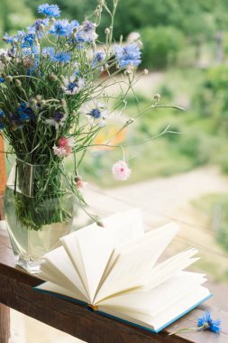 Pencere kenarında güzel bir yaz, sakin bir hayat. Bir buket çiçek ve rahat bir evin pencere eşiğinde bir kitap..