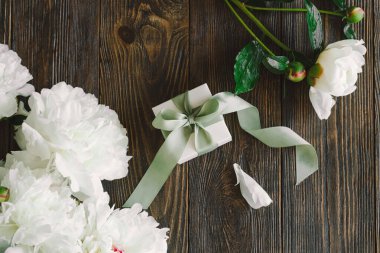 Ahşap arka planda hediye kutuları olan bir buket güzel beyaz şakayık. Şık bir çiçek selamı. Anneler Günü