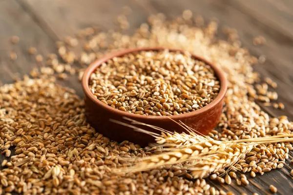 茶色の木の背景に小麦と小麦のボウルの耳 農業と小麦とパンの農業の概念 ストック写真