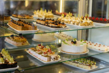 Şekerlemeli gösteri, çeşitli tatlılar ve pastanede satılık pastalar. Pastanede cam sergi..