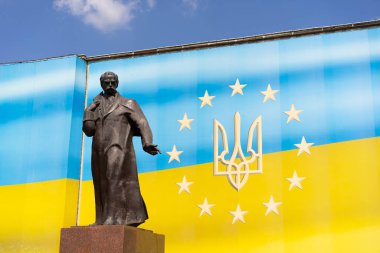 Olağanüstü Ukrayna figürü Taras Shevchenko 'nun heykeli parlak bir Ukrayna bayrağının arka planında yer alıyor. Parlak güneşli hava sahnenin görsel çekiciliğini artırır.