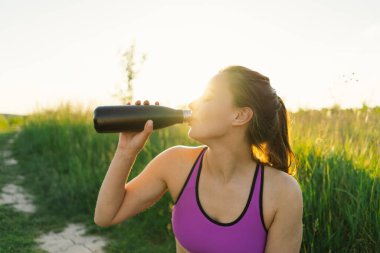 Güneşli bir yaz günbatımında spor ya da yoga yapan güzel bir kız. Vücut pozitifliği, kadınlar için spor, uyum, sağlıklı yaşam tarzı, kendini sevme ve refah..