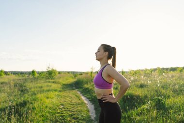 Güneşli bir yaz günbatımında spor ya da yoga yapan güzel bir kız. Vücut pozitifliği, kadınlar için spor, uyum, sağlıklı yaşam tarzı, kendini sevme ve refah..