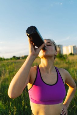 Güneşli bir yaz günbatımında spor ya da yoga yapan güzel bir kız. Vücut pozitifliği, kadınlar için spor, uyum, sağlıklı yaşam tarzı, kendini sevme ve refah..