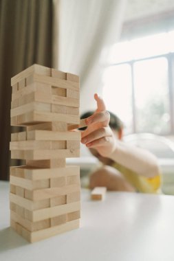 Bir baba ve oğlu kapalı alanda kule oyunu oynuyorlar. Oyun beyaz bir masada geçiyor ve arka plan odak dışı. Babalar Günü