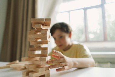 Bir baba ve oğlu kapalı alanda kule oyunu oynuyorlar. Oyun beyaz bir masada geçiyor ve arka plan odak dışı. Babalar Günü