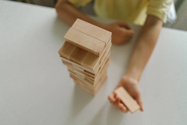 Bir baba ve oğlu kapalı alanda kule oyunu oynuyorlar. Oyun beyaz bir masada geçiyor ve arka plan odak dışı. Babalar Günü