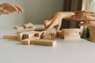 Bir baba ve oğlu kapalı alanda kule oyunu oynuyorlar. Oyun beyaz bir masada geçiyor ve arka plan odak dışı. Babalar Günü