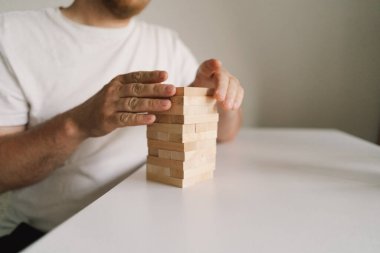 Bir baba ve oğlu kapalı alanda kule oyunu oynuyorlar. Oyun beyaz bir masada geçiyor ve arka plan odak dışı. Babalar Günü
