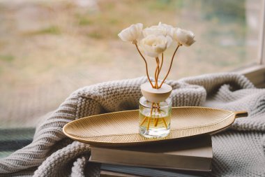 Ev için tütsü çubuklarıyla sıcak bir ortam. Çiçek kokusuyla çevrili rahat bir battaniye ve dağınık yapraklarla. Rahat bir iç mekanda huzurlu bir atmosfer yaratıyor..