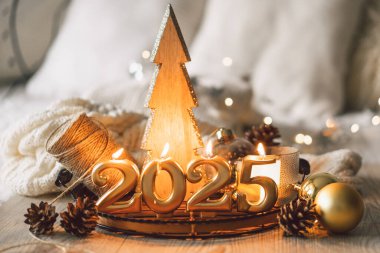 Anlaşmada 2025 'i temsil eden altın rakamlar, yanan mumlar ve Noel dekoru yer alıyor. Yeni yıl kutlamaları için mükemmel bir ortam yaratıyor..