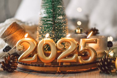 Anlaşmada 2025 'i temsil eden altın rakamlar, yanan mumlar ve Noel dekoru yer alıyor. Yeni yıl kutlamaları için mükemmel bir ortam yaratıyor..