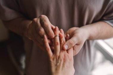 A couple shares a special moment as one partner places an engagement ring on the others finger. Romantic gesture. Happy Valentines Day. clipart