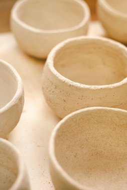 Çömlek atölyesinde basit seramik kaplar yapmak. Güneş ışığı ince işçiliği aydınlatır..