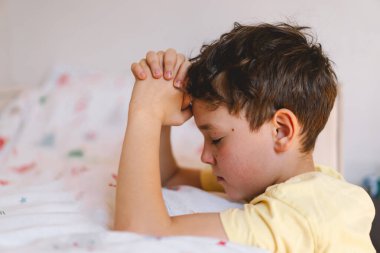Elleri bağlı bir çocuk, dua ediyor ya da meditasyon yapıyor. Hıristiyanlık, din ve inanç kavramı.