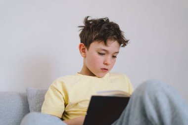 Bir çocuk kutsal kitabı okuyor ve dua ediyor ya da meditasyon yapıyor. Hıristiyanlık, din ve inanç kavramı.