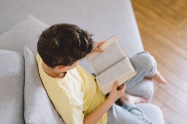 Bir çocuk kutsal kitabı okuyor ve dua ediyor ya da meditasyon yapıyor. Hıristiyanlık, din ve inanç kavramı.