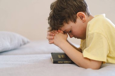 Elleri bağlı bir çocuk, dua ediyor ya da meditasyon yapıyor. Hıristiyanlık, din ve inanç kavramı.