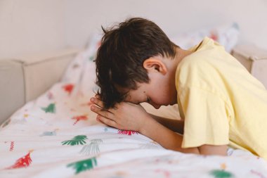 Elleri bağlı bir çocuk, dua ediyor ya da meditasyon yapıyor. Hıristiyanlık, din ve inanç kavramı.