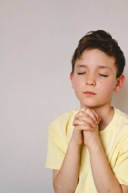 Elleri bağlı bir çocuk, dua ediyor ya da meditasyon yapıyor. Hıristiyanlık, din ve inanç kavramı.