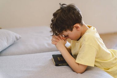 Elleri bağlı bir çocuk, dua ediyor ya da meditasyon yapıyor. Hıristiyanlık, din ve inanç kavramı.