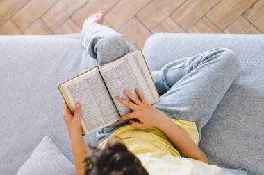 Bir çocuk kutsal kitabı okuyor ve dua ediyor ya da meditasyon yapıyor. Hıristiyanlık, din ve inanç kavramı.