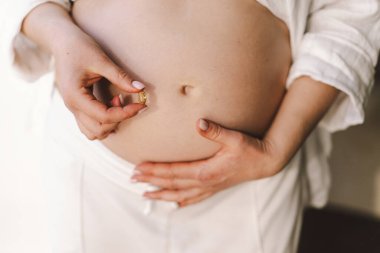 Kendisine ve bebeğine bakabilmek için vitamin taşıyan hamile bir kadın. Hamilelik ve Sağlık Konsepti